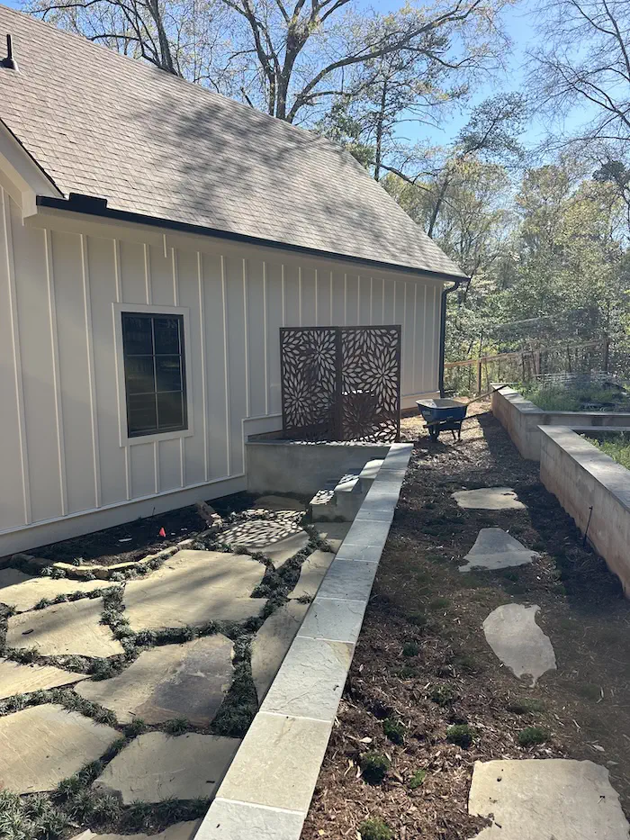 Backyard landscape with stone pathway and garden bed under construction.